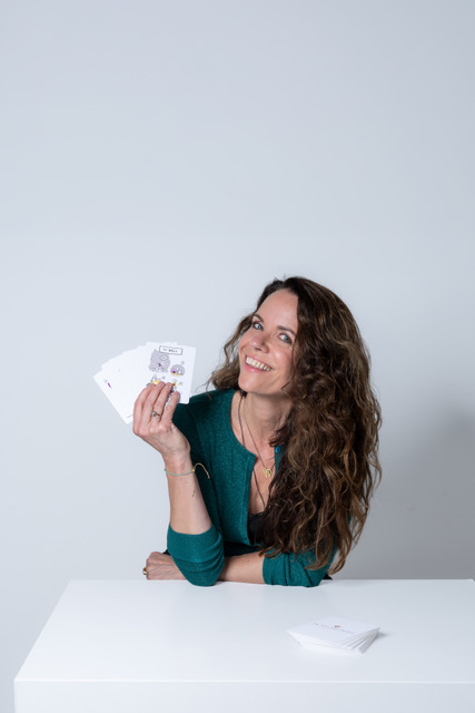 Sylvia lachend met een waaier State Shift kaarten in haar hand