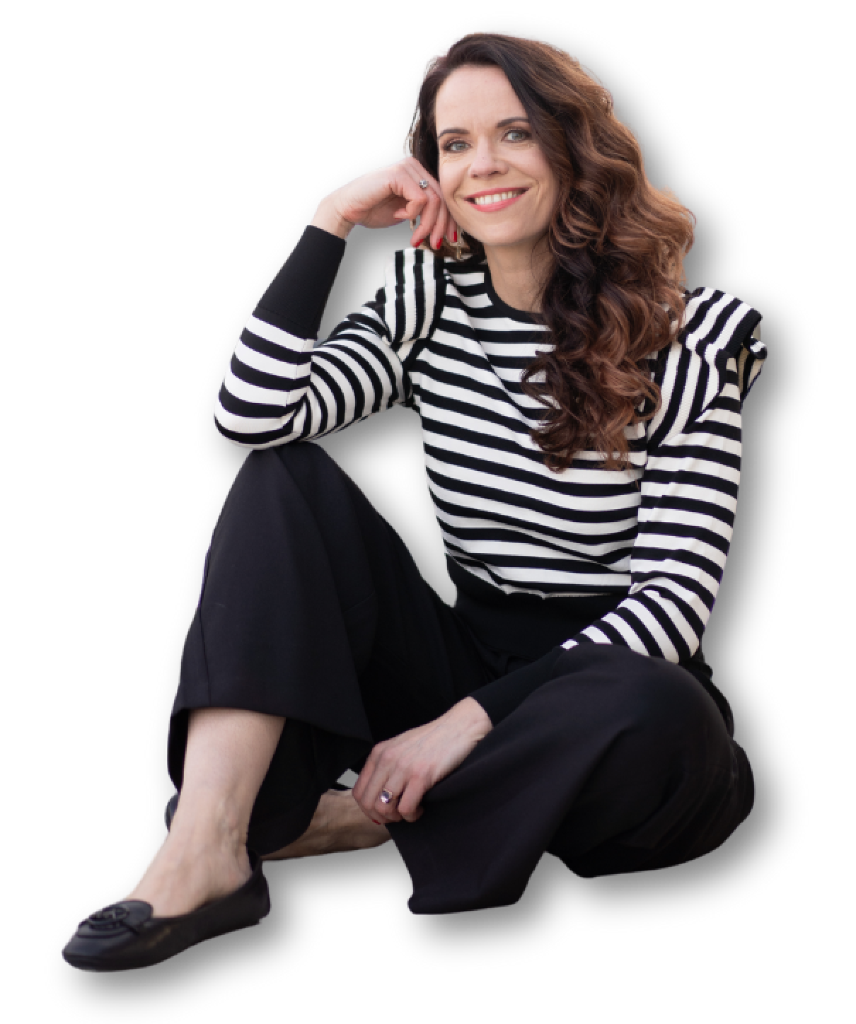 Sylvia sitting down wearing a black and white stripped top and black trousers